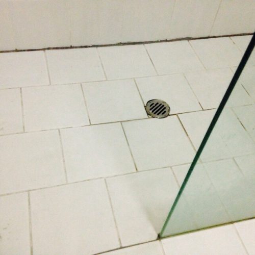 Tiled shower base missing grout with water damage