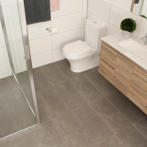 Wall hung toilet with shower and white wall tiles and double vanity