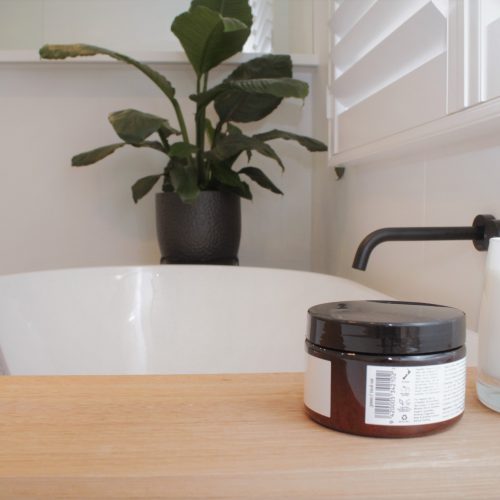 Solid timber bath caddy on freestanding bath with matte black wall mounted bath spout